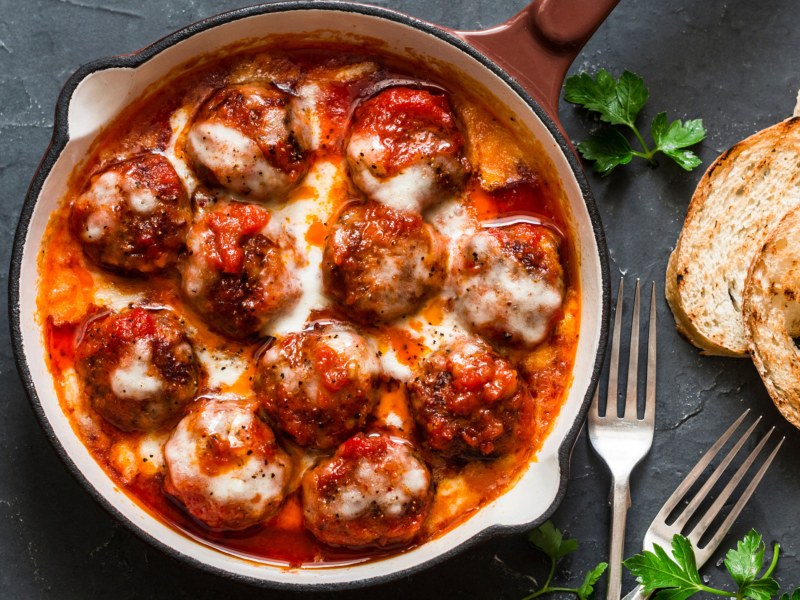 Hackb&auml;llchen mit Tomatenso&szlig;e und K&auml;se &uuml;berbacken in einer tiefen Pfanne.