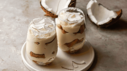 Zwei Gläser mit Kokos-Tiramisu auf einem Tisch.