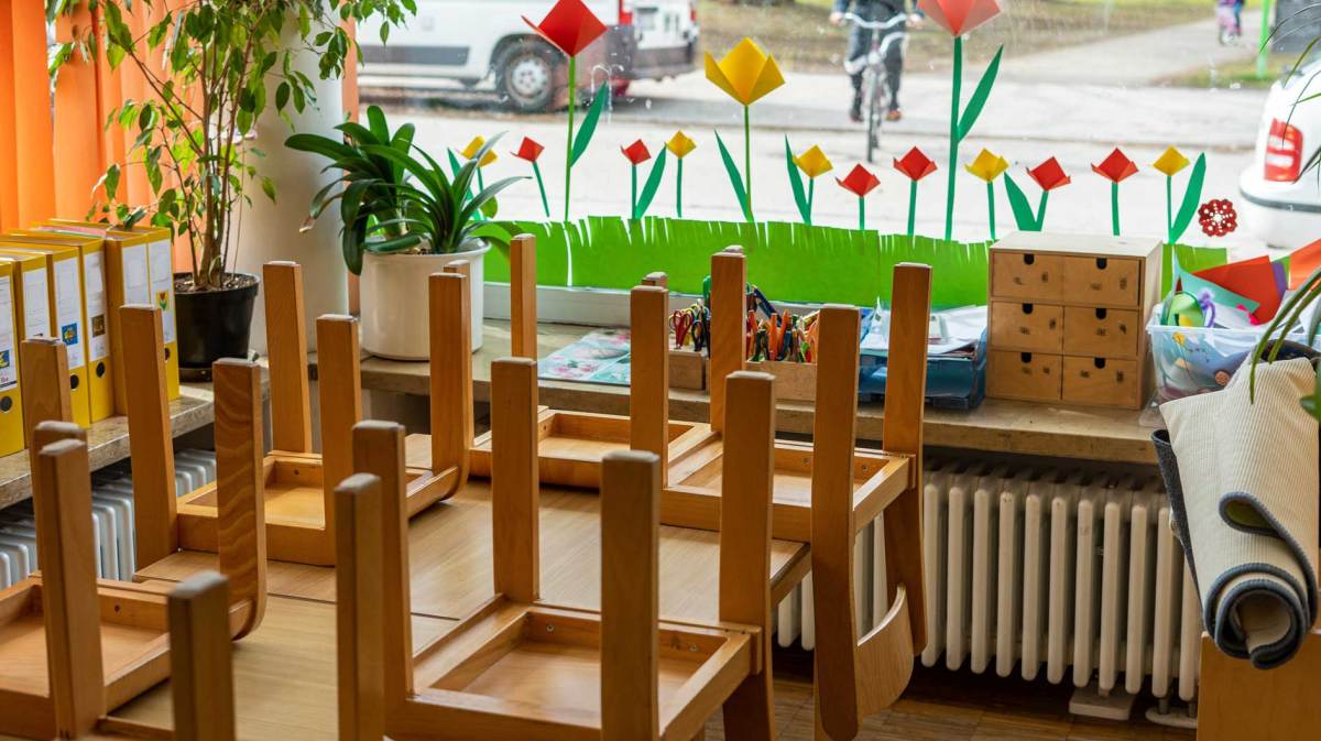Bild einer leeren Kindertageseinrichtung. Die Stühle sind auf die Tische gestellt.