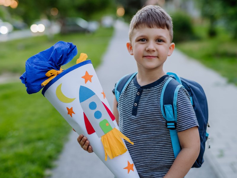 Junge mit Schultüte auf dem Weg zu seinem ersten Schultag.