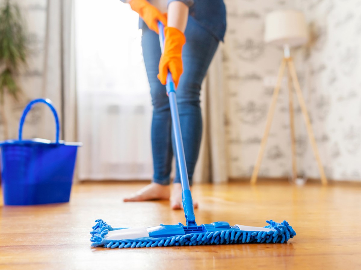Frau wischt mit Mopp &uuml;ber Boden.