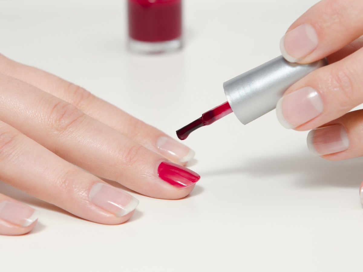 Frau, die roten Nagellack auftr&auml;gt