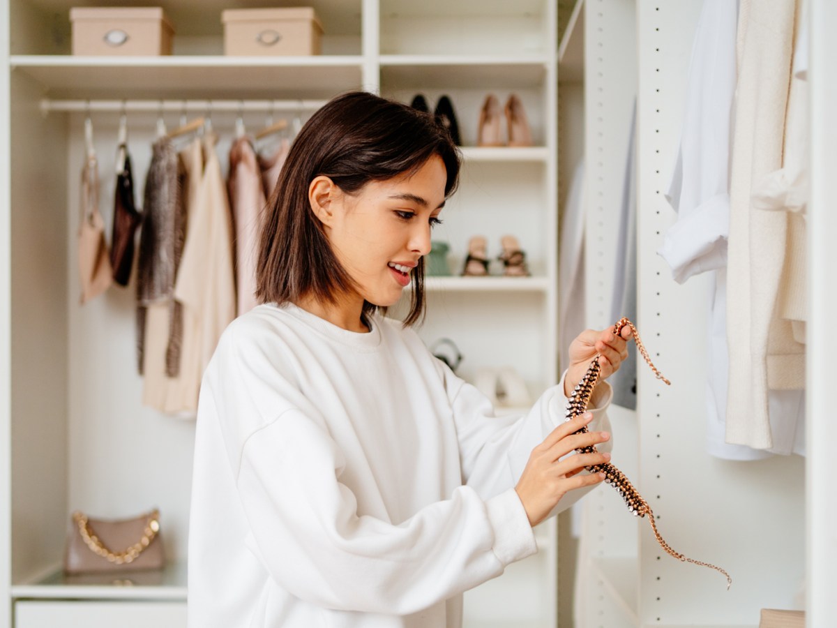 Frau, die ihren Kleiderschrank aussortiert und aufr&auml;umt.