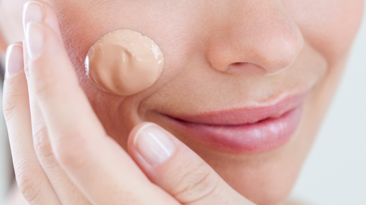 Frau mit einem Tropfen Make-up auf der Wange.