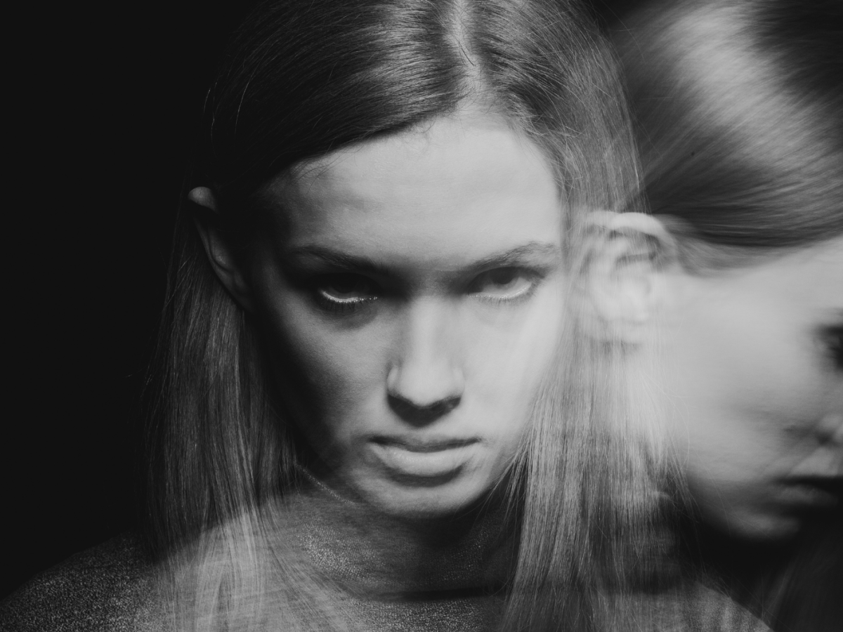 Frau in zwei Momentaufnahmen, die ernst in schwarz-wei&szlig; in die Kamera blickt.