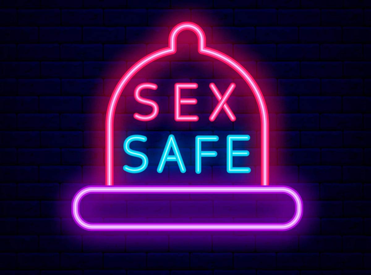 Sex Safe Leuchtreklame mit Kondom Rahmen auf Backsteinmauer Hintergrund