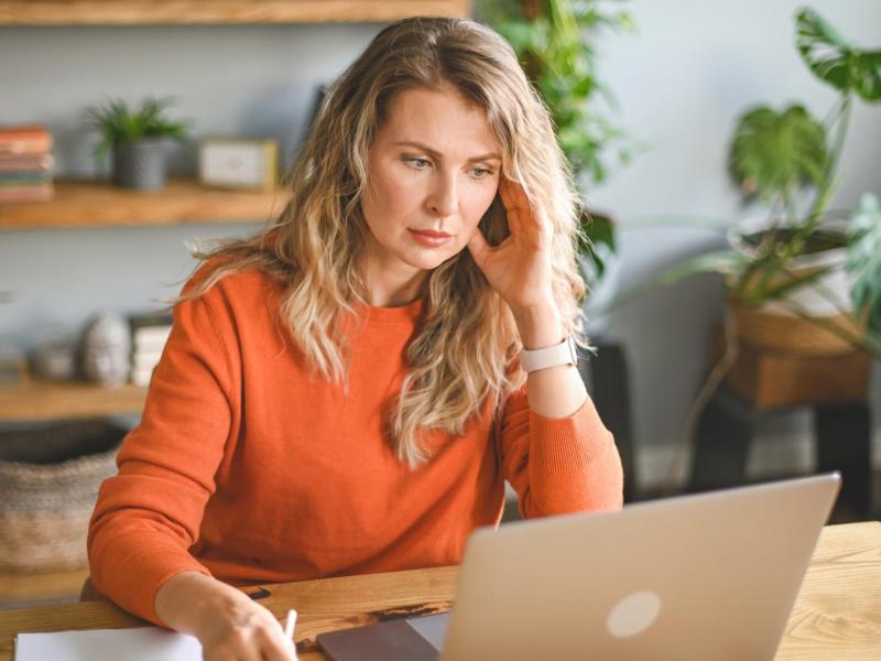 Frau sitzt vor einem Laptop.