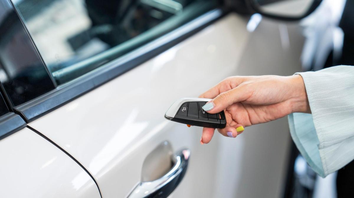 Frau hält einen Autoschlüssel in der Hand.