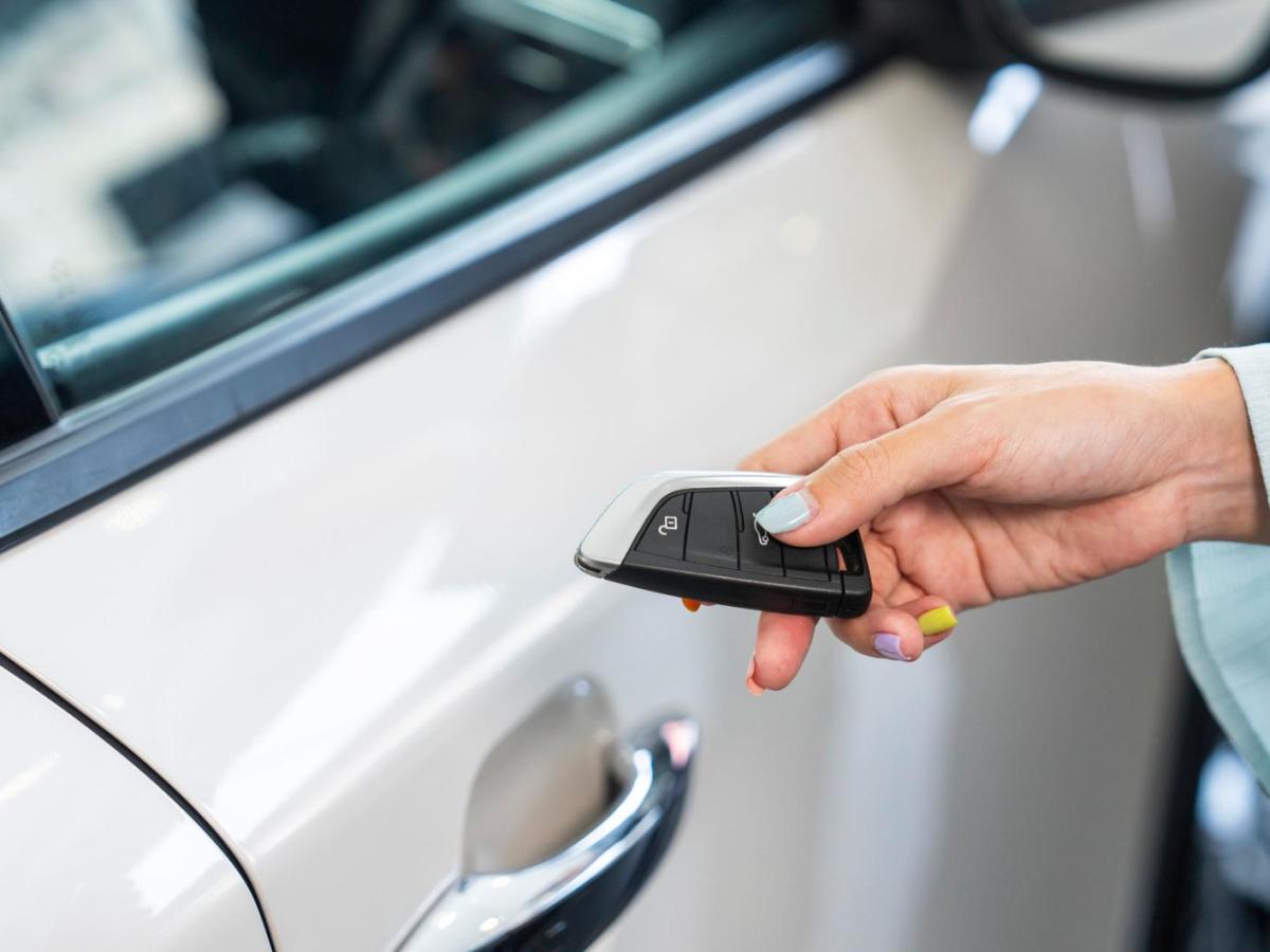Frau hält einen Autoschlüssel in der Hand.