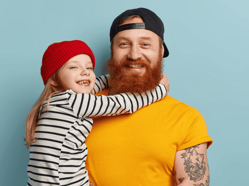 Vater hält kleines Mädchen auf dem Arm, das lacht