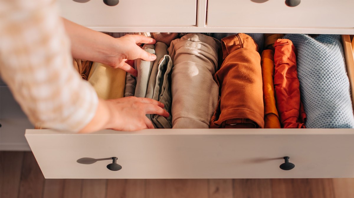 Aufgeräumte Schublade im Kleiderschrank mit sortierten Klamotten.