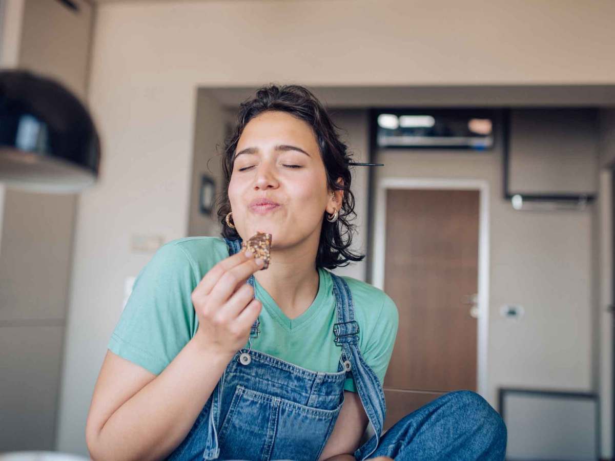 Frau isst gen&uuml;sslich einen Keks.