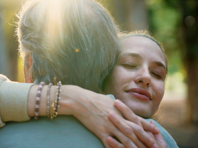 Tochter umarmt ihre Mutter im Wald