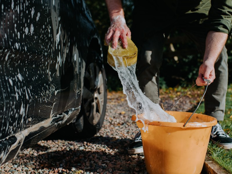 Mann beim Auto waschen
