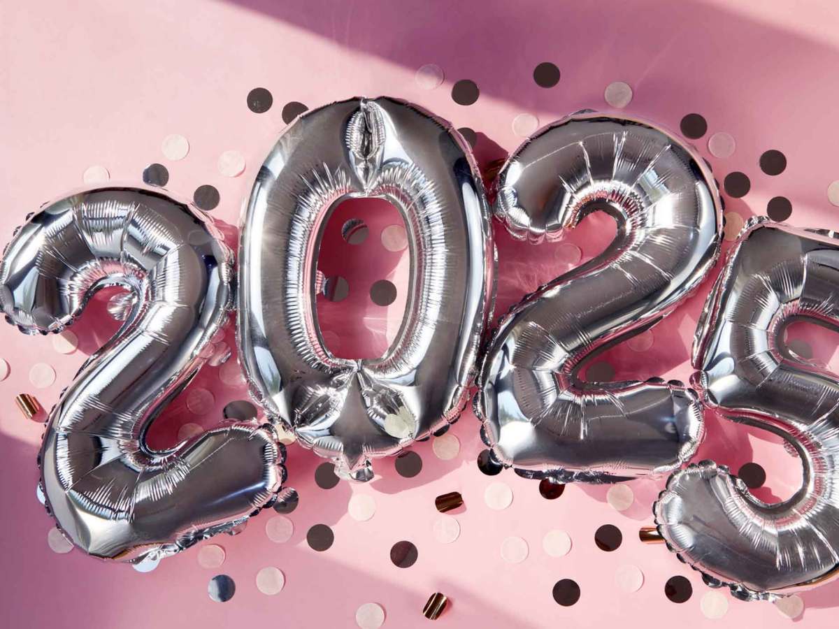 Silberne Ballons, die eine 2025 bilden und vor einem rosa Hintergrund sind.