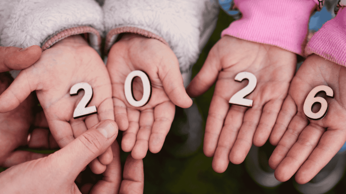 Kleine Holzzahlen 2026 liegen in kleinen Kinderhänden