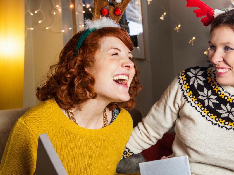 Zwei Frauen schenken sich gegenseitig etwas zu Weihnachten.