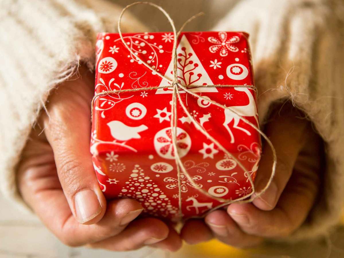 Frau hält ein kleines rotes Wichtelgeschenk.