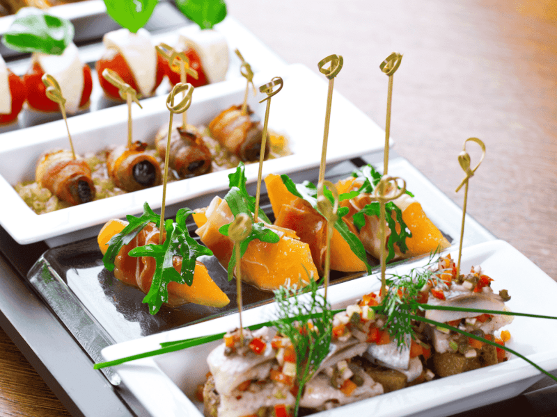 Fingerfood auf weißen Platten angerichtet.