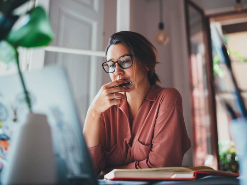 Frau sitzt an ihrem Laptop