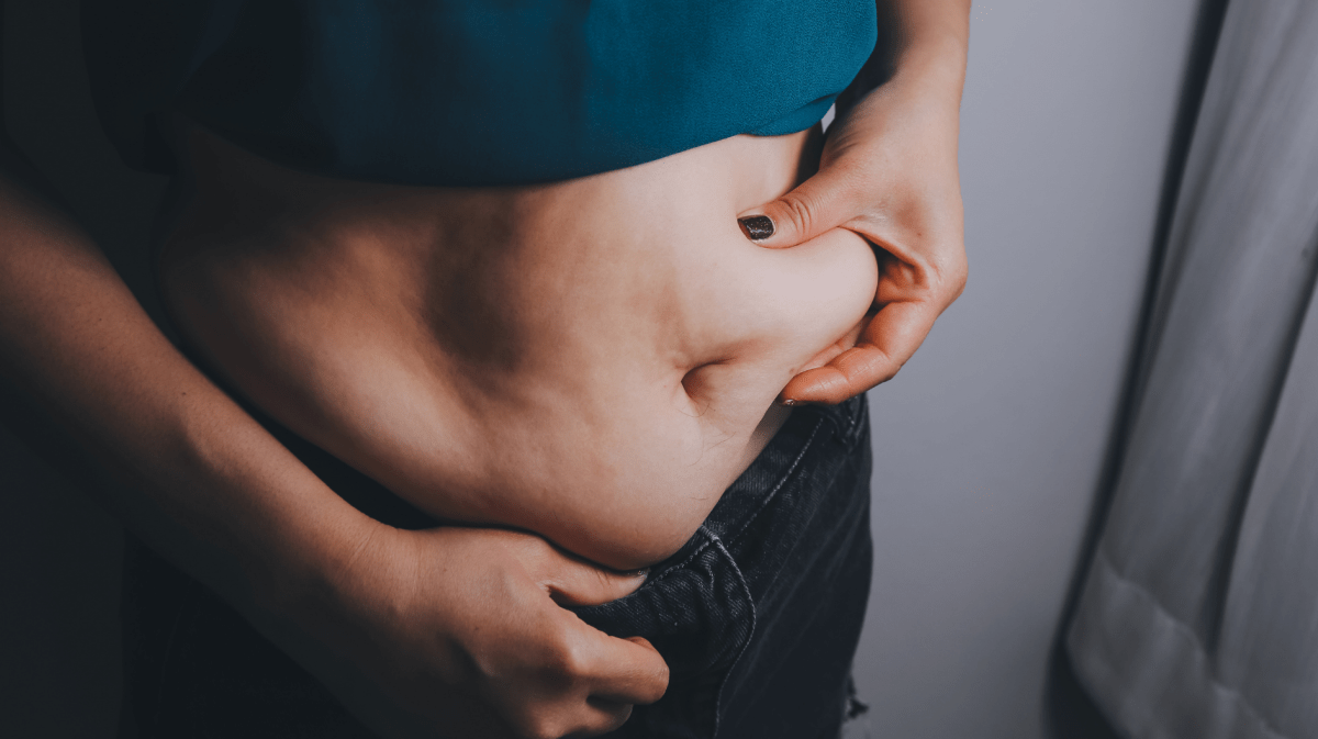 dicke Frau, dicker Bauch, mollig, fettleibige Frau Hand hält übermäßiges Bauchfett mit Maßband, Frau Diät Lebensstil Konzept