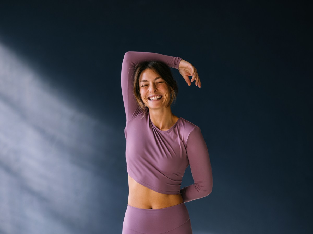 Frau in lila Sportkleiung l&auml;chelt