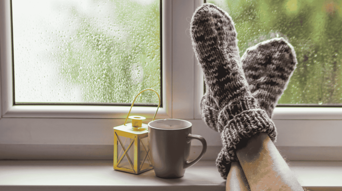 Mann hat Füße auf Fensterbank abgelegt.