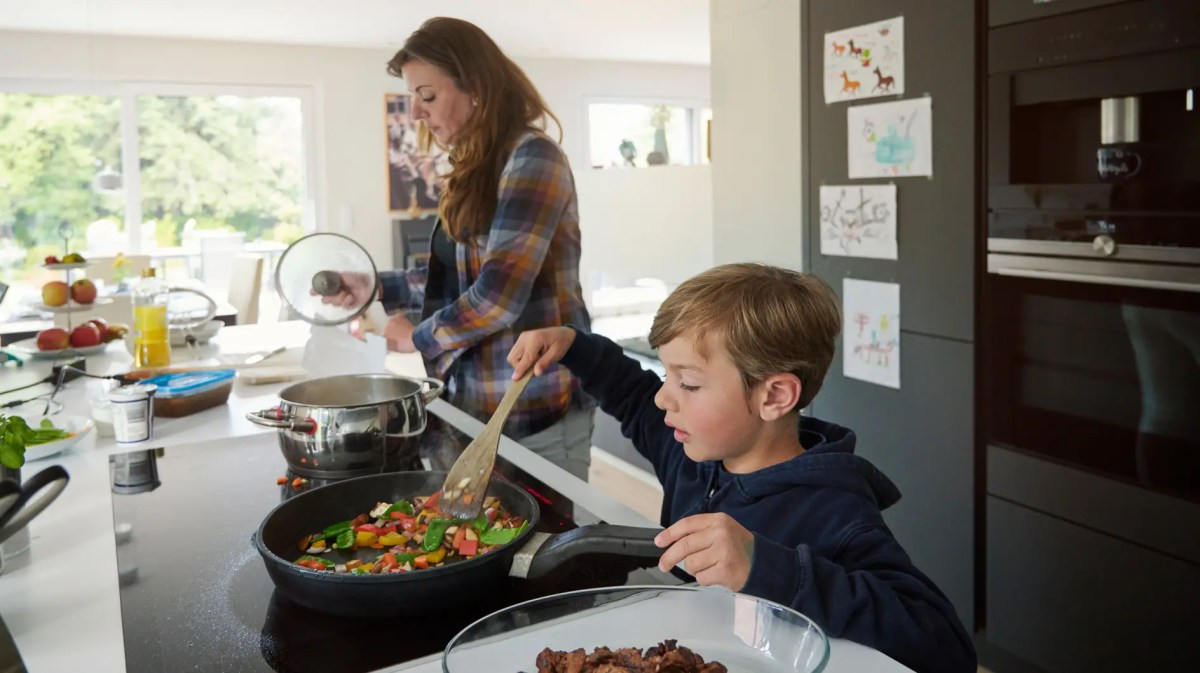 Mutter und Sohn kochen gemeinsam in der Küche.