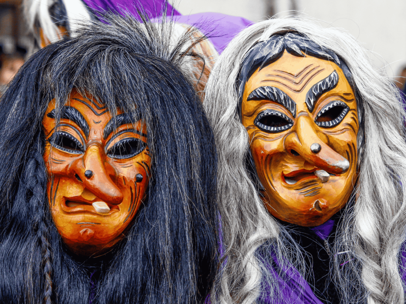 Zwei als Hexen kostümierte Narren der Narrenzunft Bondorf mit Holzmasken und Perücken beim Umzug zur schwäbisch-alemannischen Fastnacht ("Fasnet") bei Tübingen