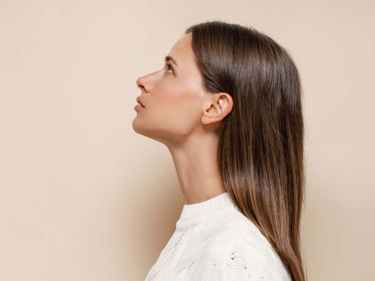 Frau mit einem weißen Pulli schaut ernst nach oben