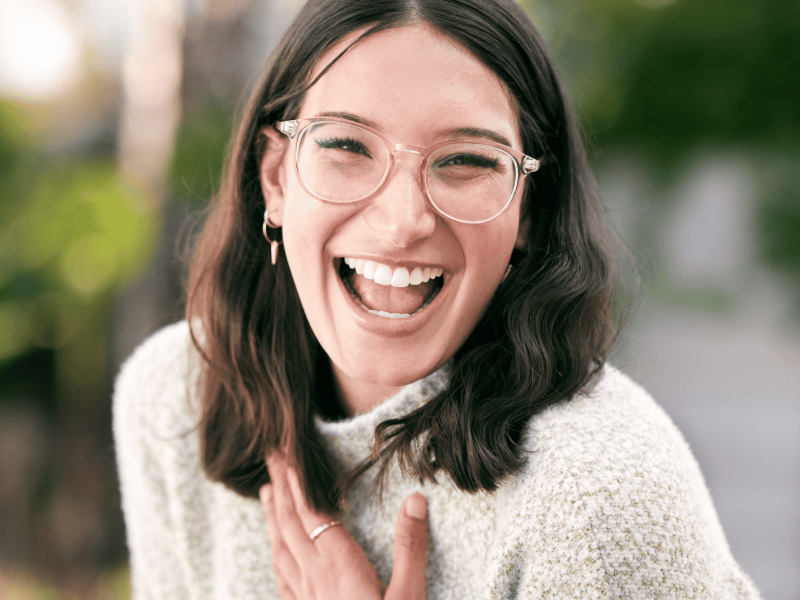 Frau mit Brille lächelt strahlend in die Kamera