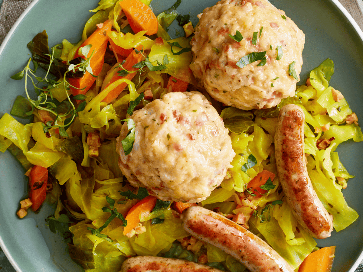 Speckknödel auf Schmorkohl: So gelingt der deftige Hüttenklassiker