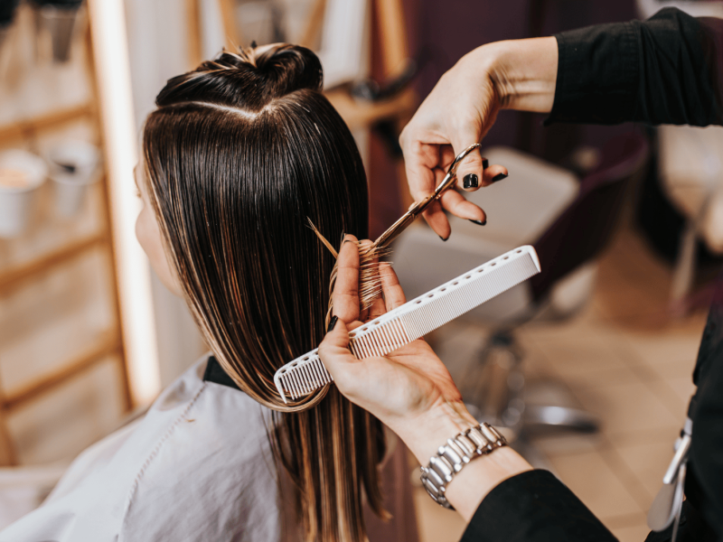 Frau sitzt beim Friseur.