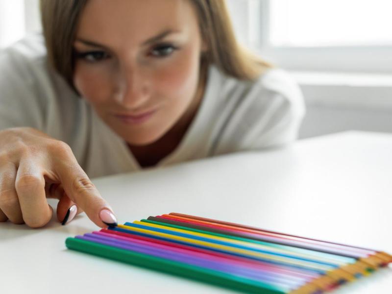 Frau sortiert Buntstifte.