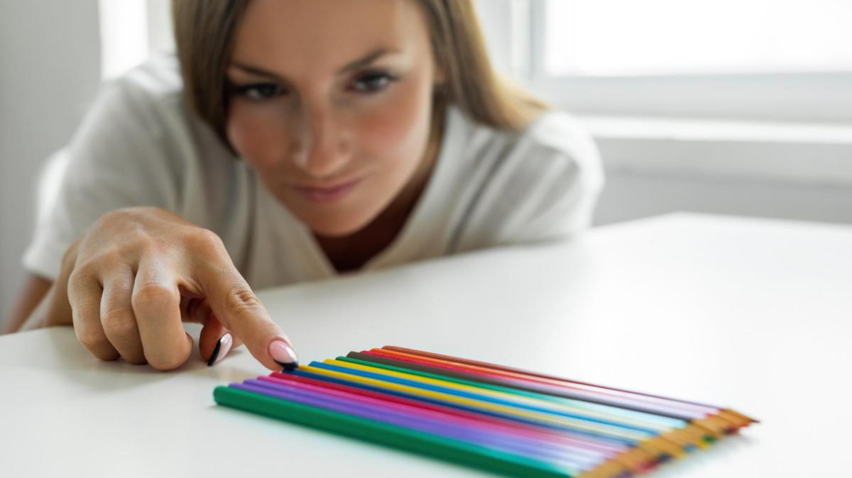 Frau sortiert Buntstifte.