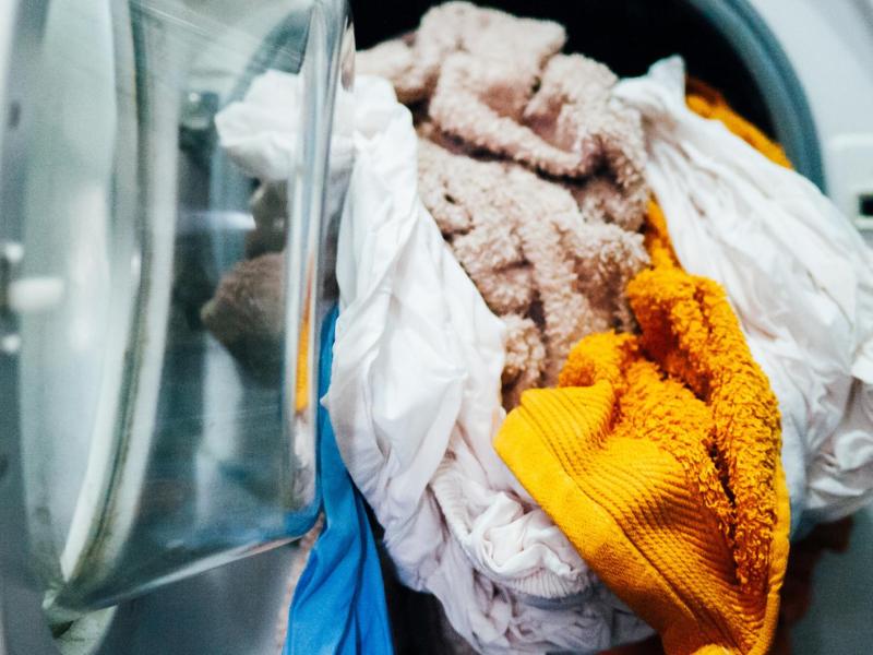 Handtücher mit verschiedenen Farben sind nass in der Waschmaschine.