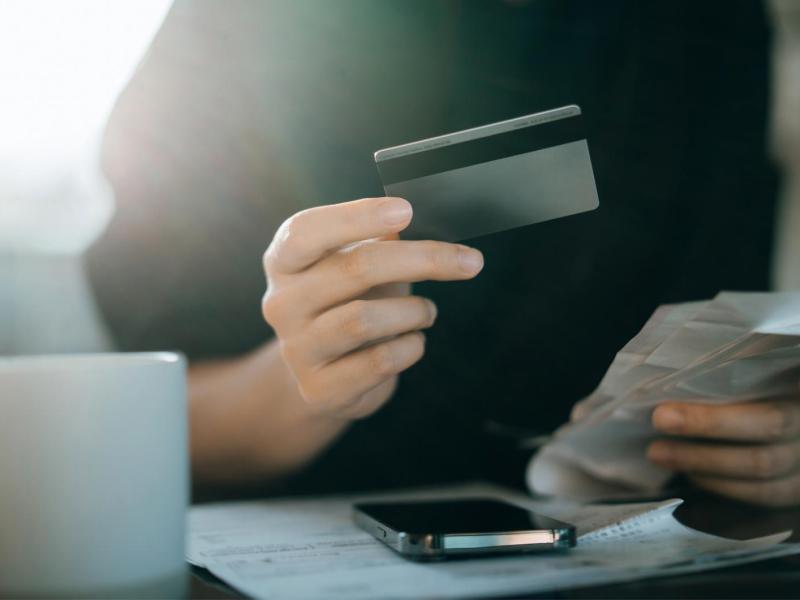 Frau hält eine Bankkarte in der Hand.