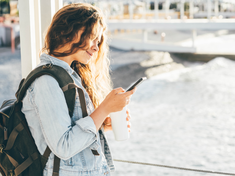 Frau telefoniert am Meer.