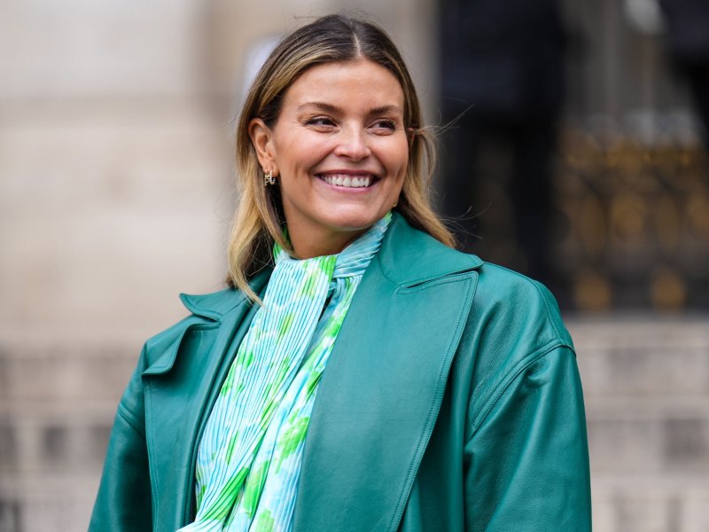 Frau mit grüner Bluse und grünem Blazer in unterschiedlichen Nuancen.