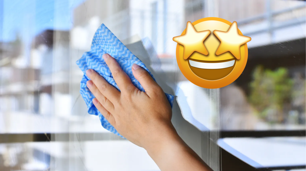 Hand mit blauem Lappen putzt Fenster, daneben Emoji