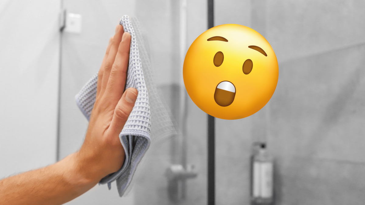 Eine Person putzt eine glänzende Dusche mit einem Lappen