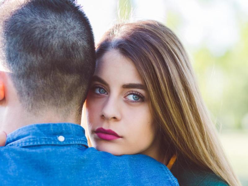 Frau lehnt sich traurig auf der Schulter ihres Partners ab.