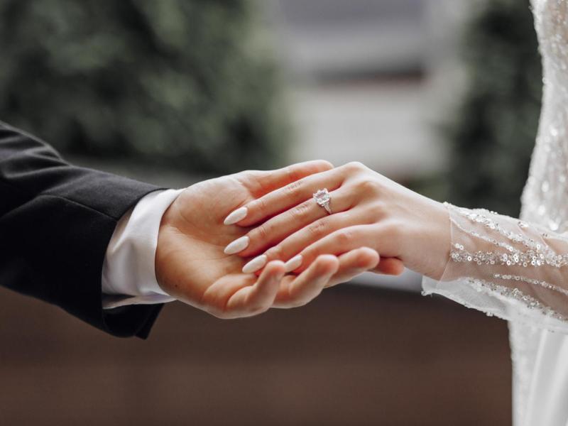 Bräutigam hält die Hand seiner Braut sanft.