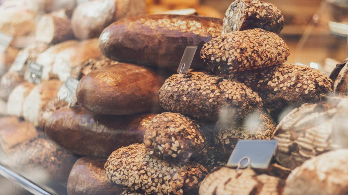 Brötchen liegen bei einem Bäcker hinter einer Glasscheibe aus.