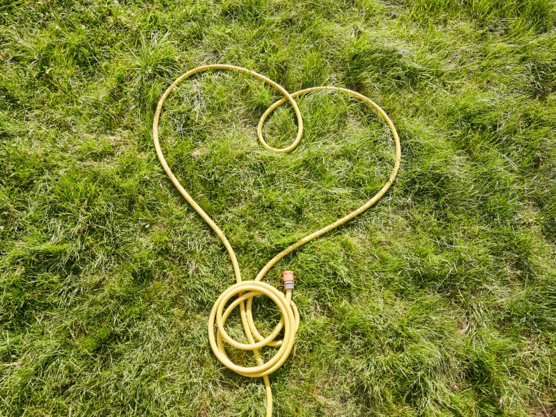 Gartenschlauch als Herz auf Rasen