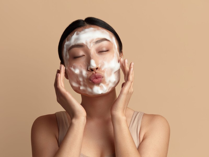 Frau, die sich das Gesicht mit Schaum einseift.