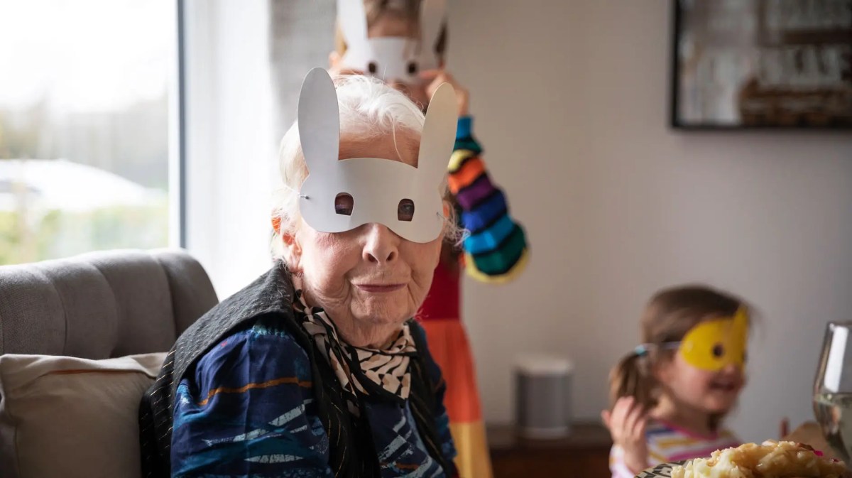 Großmutter und Enkelkinder tragen Hasenmasken.