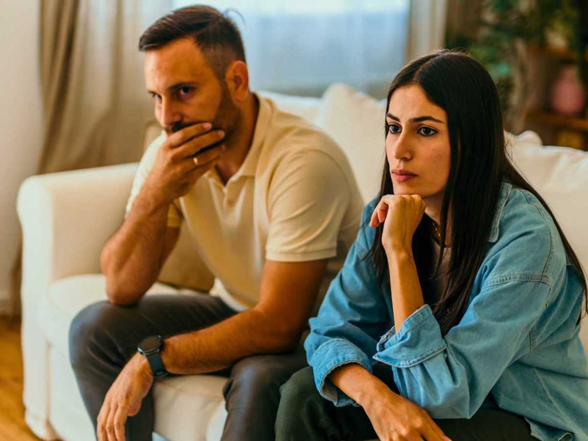 Paar sitzt nachdenklich auf der Couch.