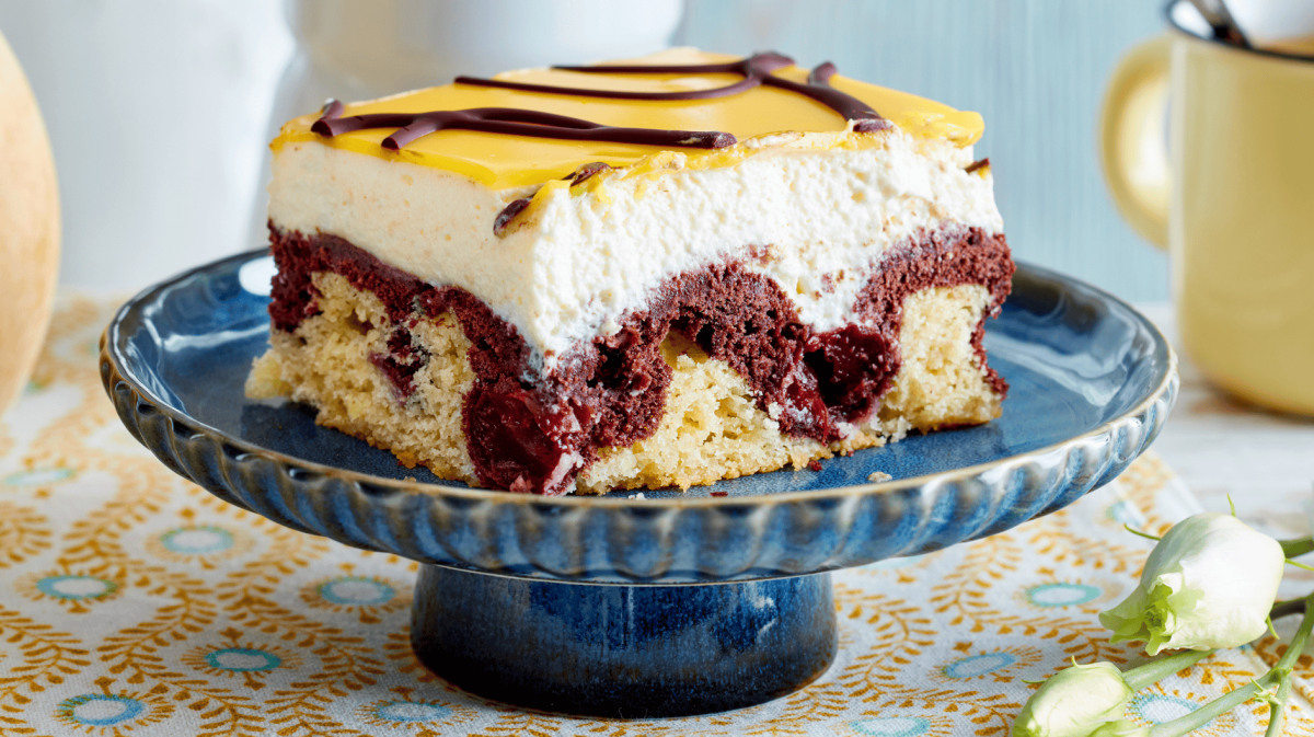 Donauwelle mit Eierlikör auf einem blauen Kuchenständer.