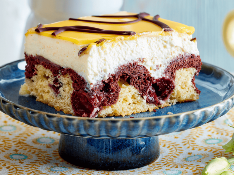 Donauwelle mit Eierlikör auf einem blauen Kuchenständer.